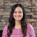 Monica Merritt, a Vantegic Home Team client from Fountain, smiling in front of a stone wall.